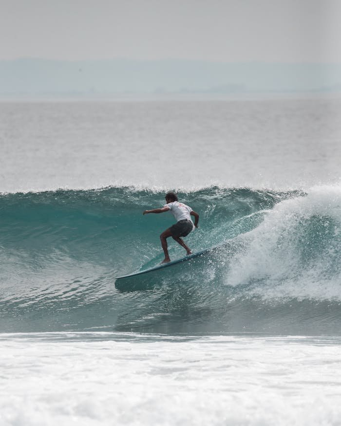 Action shot of a surfer skillfully riding a wave under clear skies.